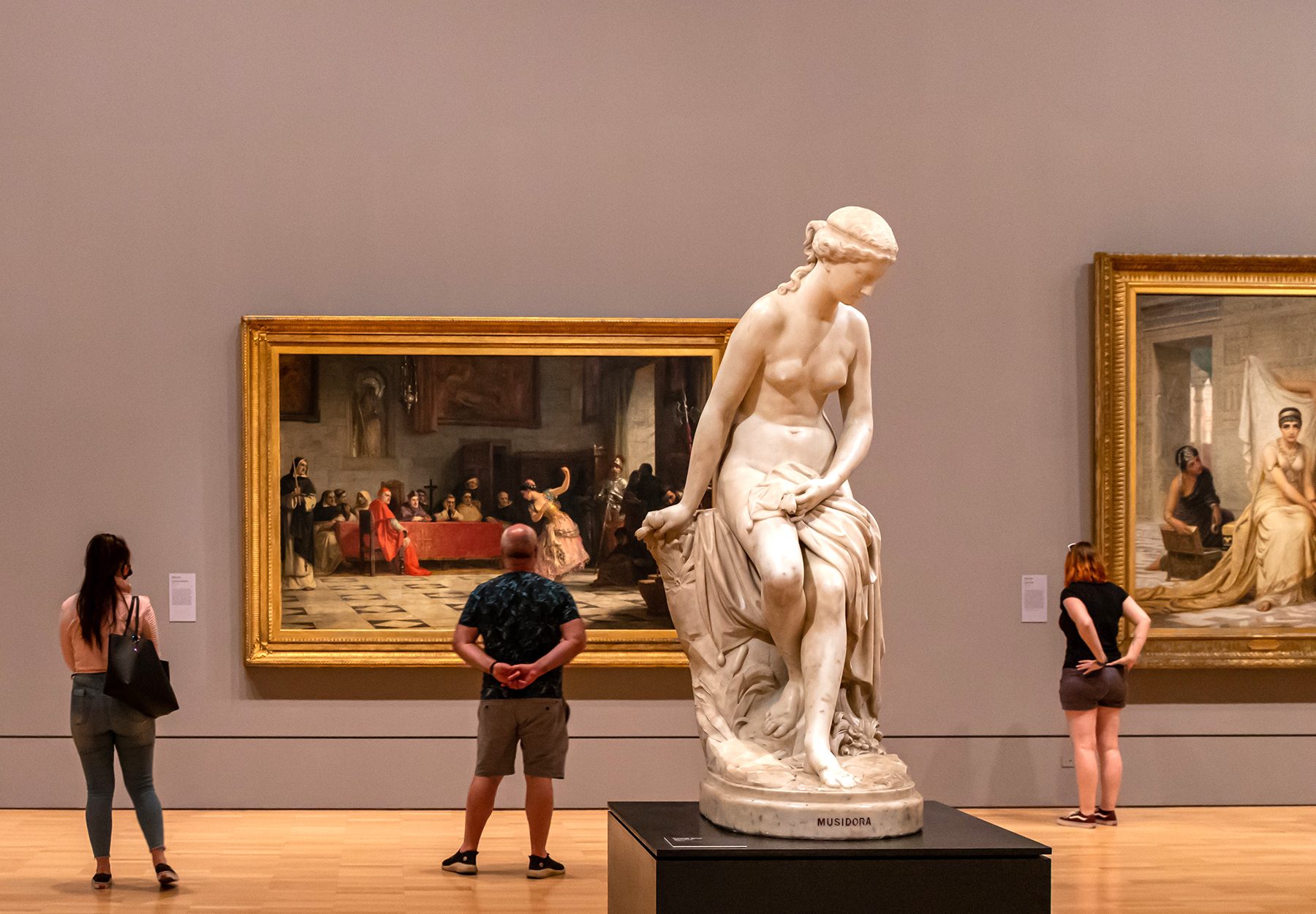 People in background admiring art behind white statue of Musidora Event Logistics Freight forwarding